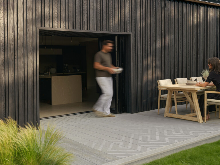 Modello Linear Smoked Oak man walking onto deck